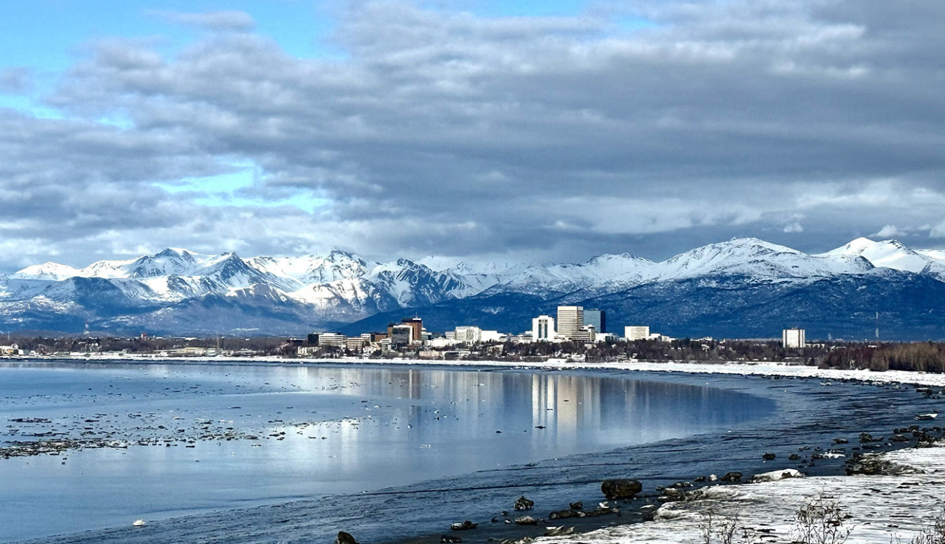A bay with buildings and mountains in the distance.