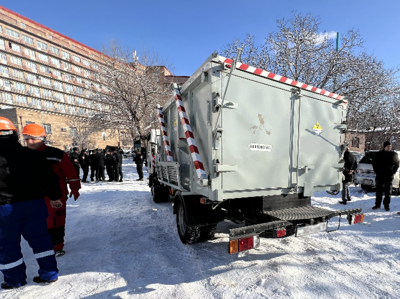 A truck is holding the nuclear material is parked outside a building. Snow is on the ground.