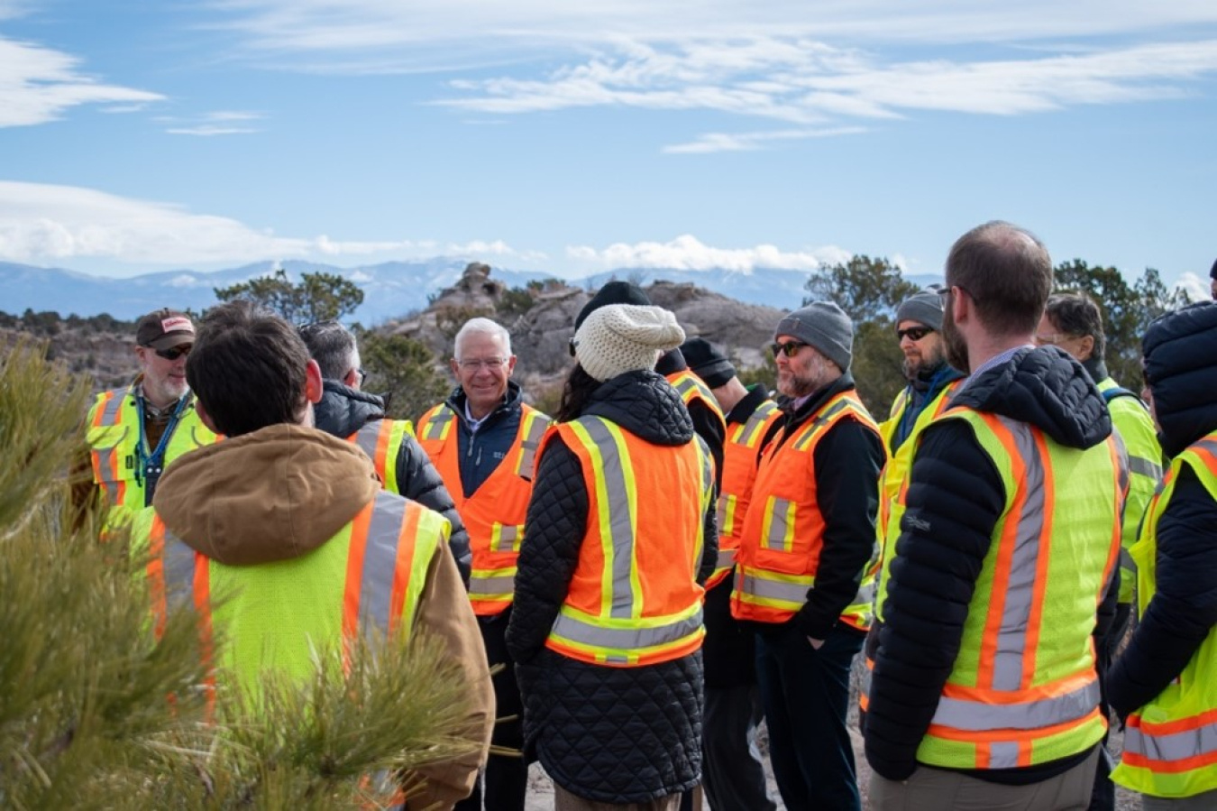 A group of people in safety vests taking a tour of a canyon in Los Alamos