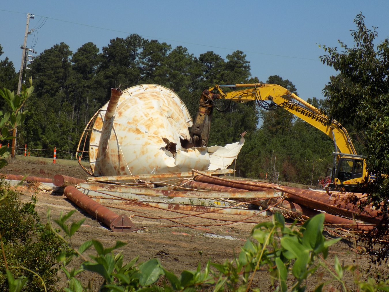 A large white water tower being demolished by construction vehicles at the Savannah River Site