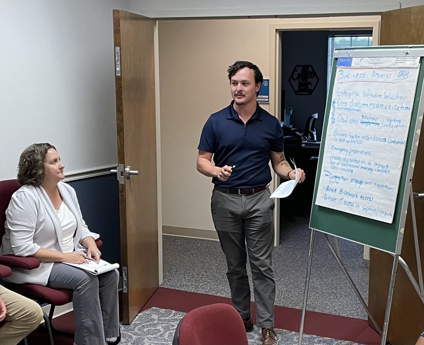 SEPA Employees discussing items written on easel.