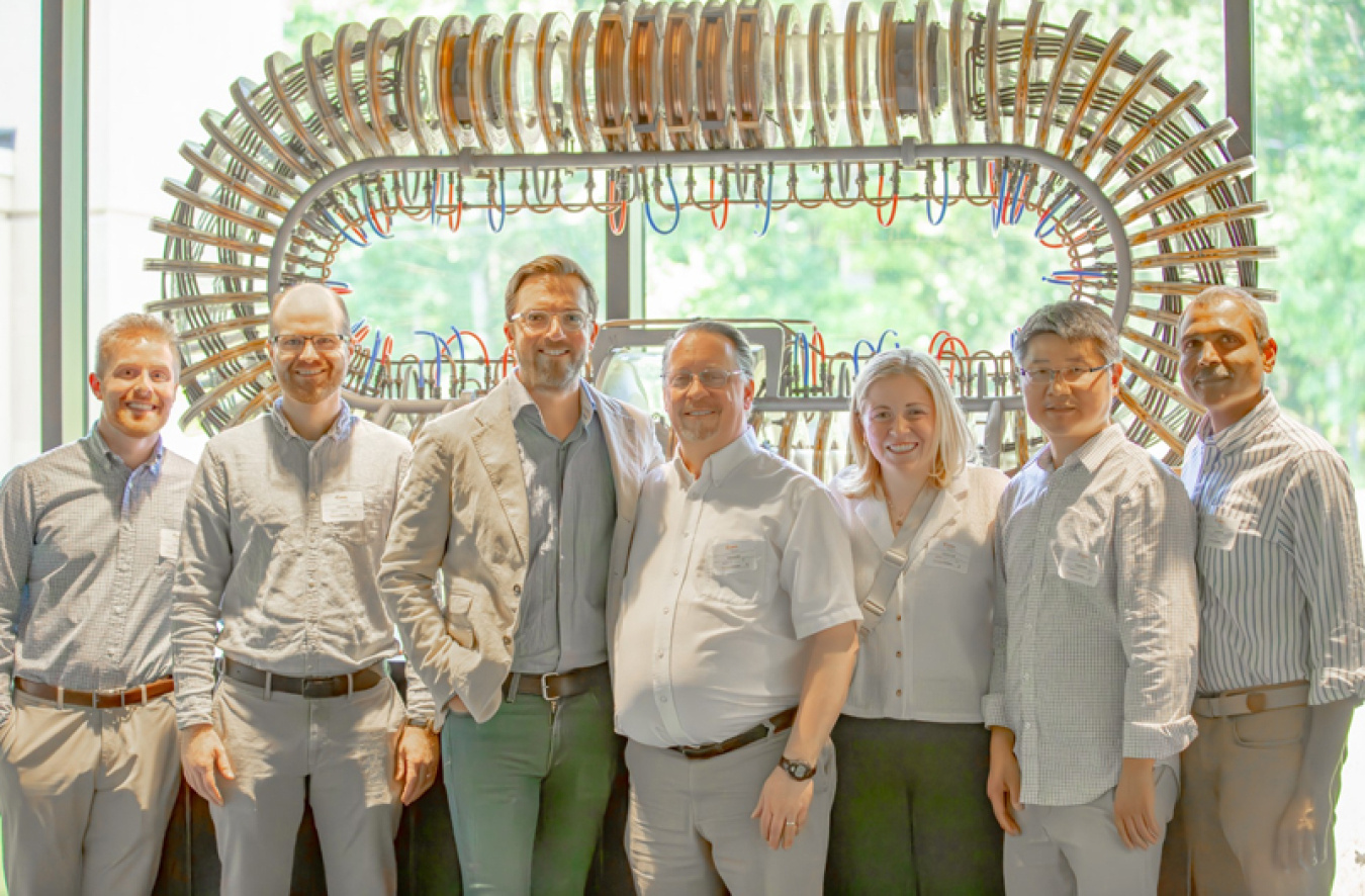 The Thea Energy team in front of DOE’s Princeton Plasma Physics Laboratory model stellarator exhibited at the 1958 Atoms for Peace conference in Geneva, Switzerland.