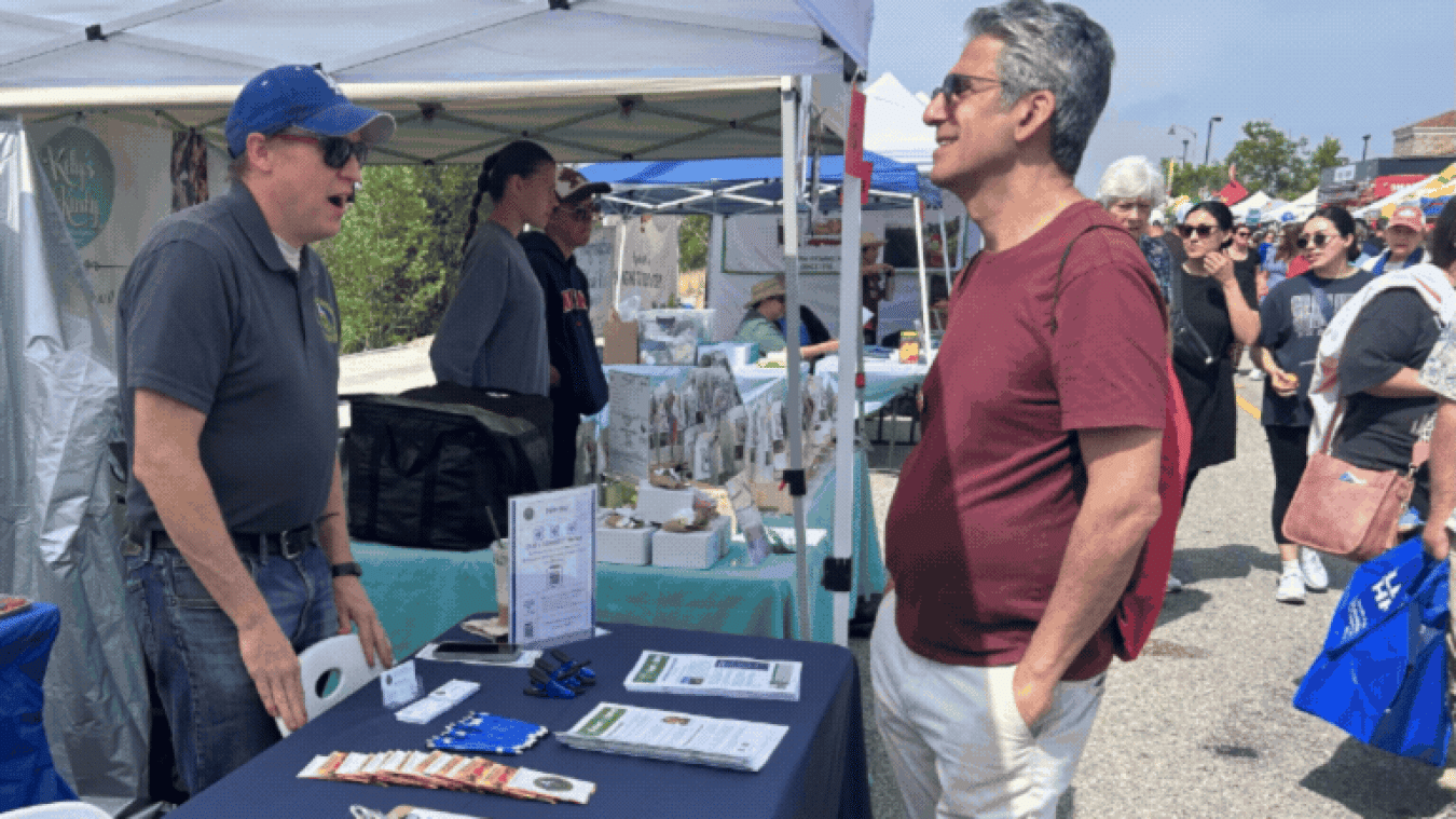 Rotating set of images of an ETEC Site booth at a street fair 