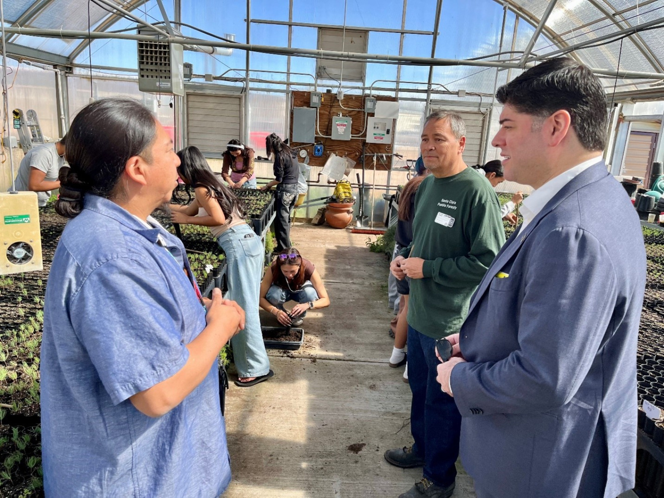 A group of people touring a greenhouse 