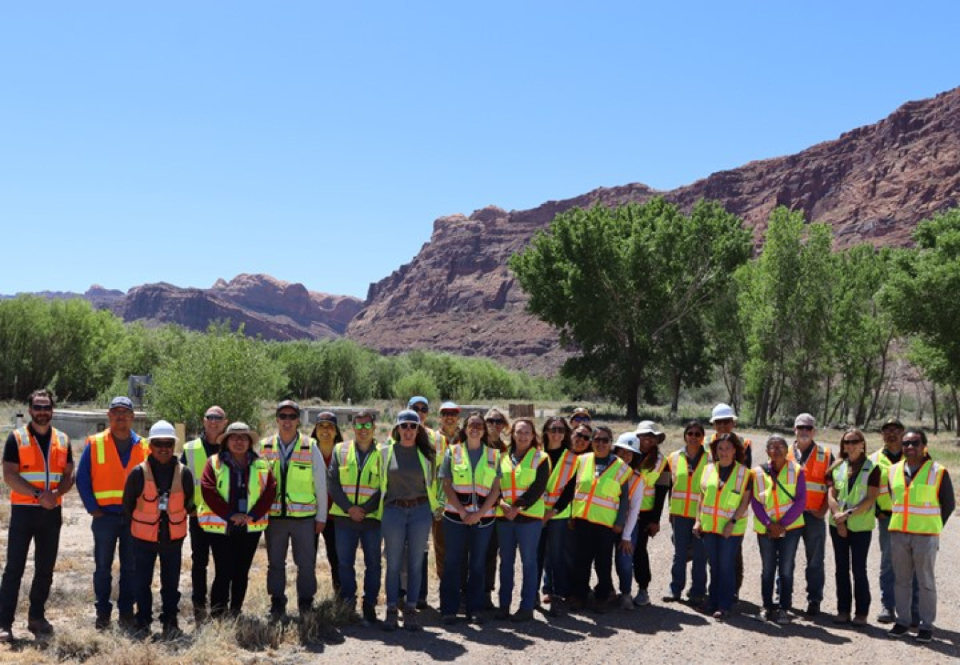 A group of people in safety vests pose for a group photo at the Moab Site