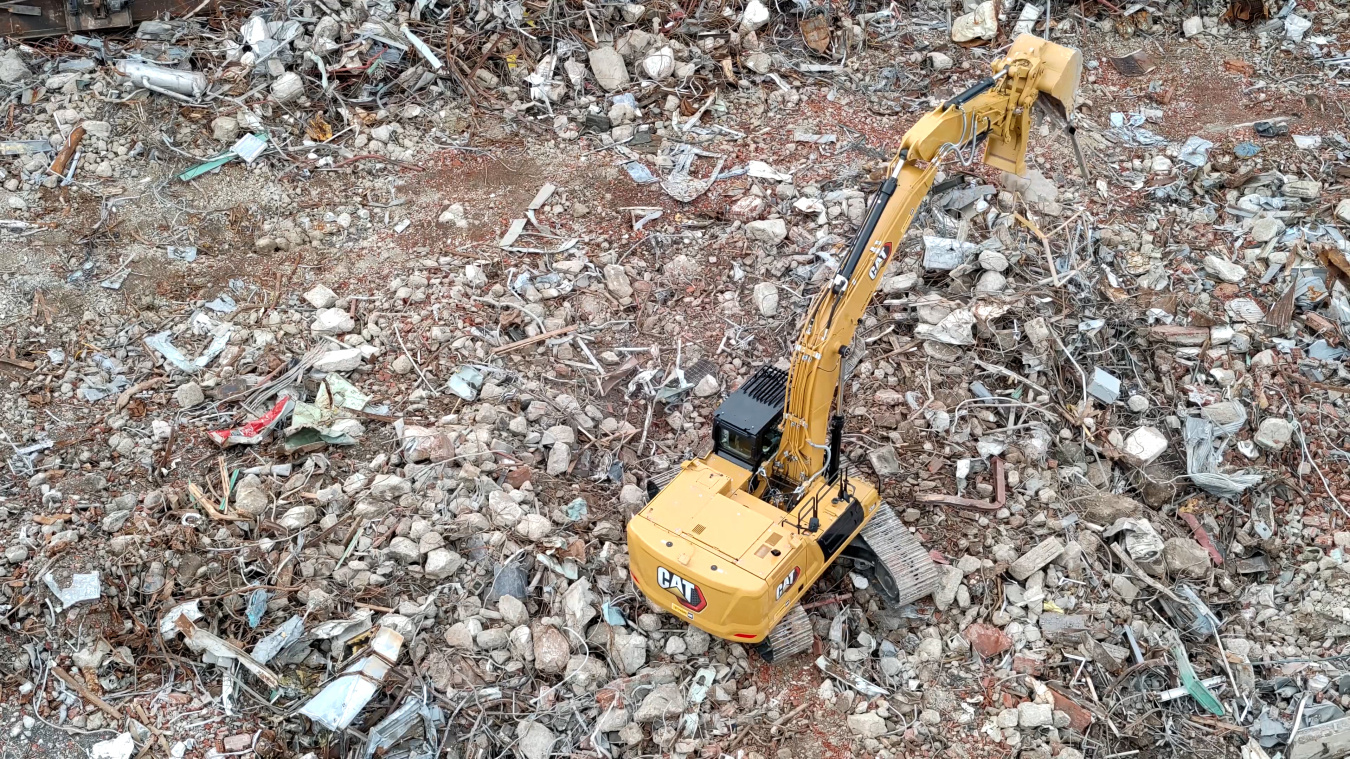 A yellow construction vehicle surrounding by debris