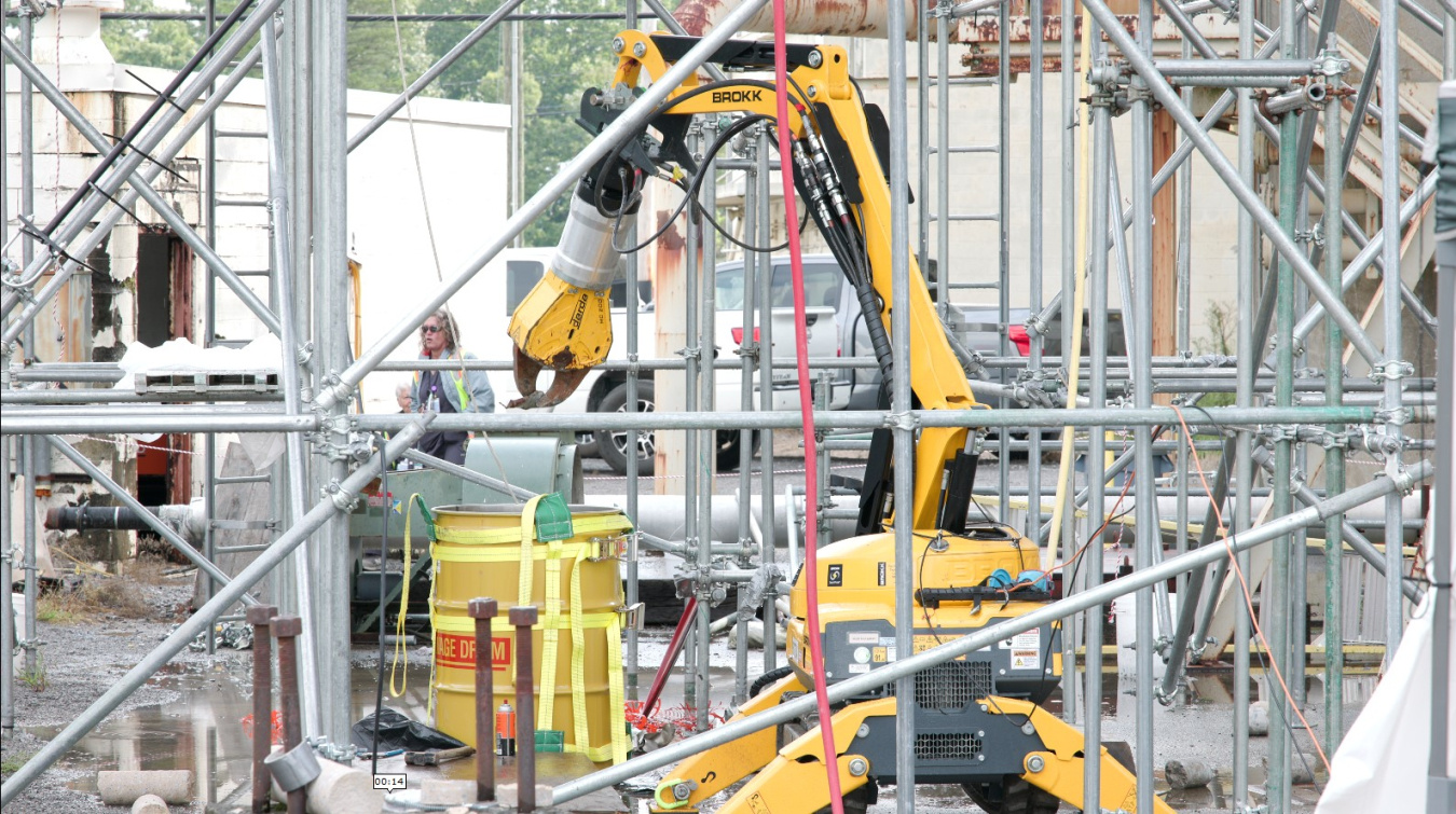 A large yellow robotic arm doing a mock-up demonstration at the Oak Ridge Site