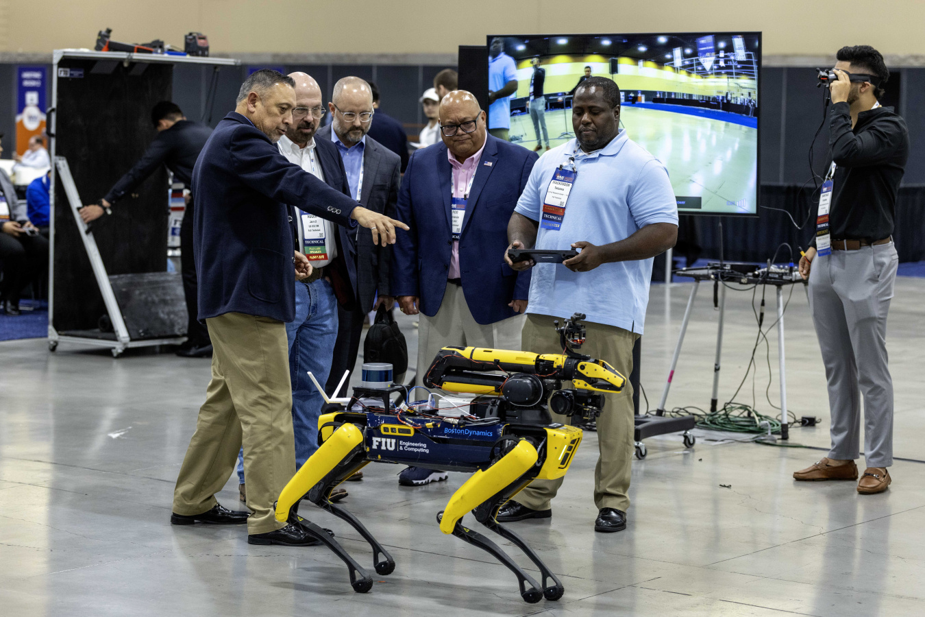 A group of people standing around a robotic dog.