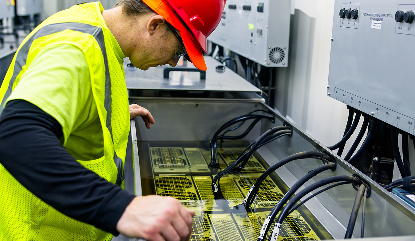 A technician working on an immersion cooling system in a data center