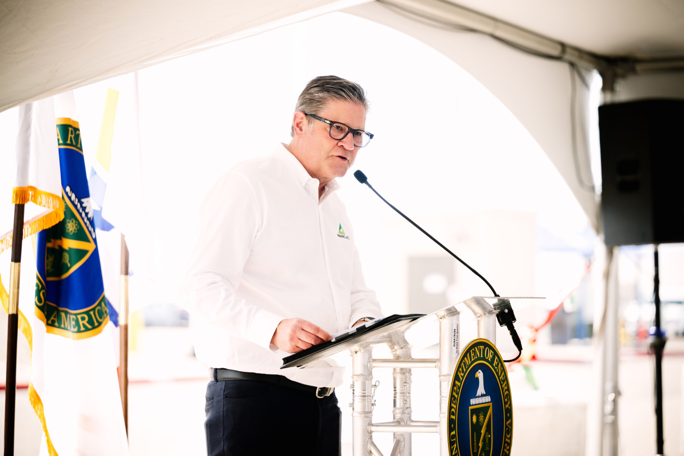 A man on stage speaking to a crowd from behind a podium