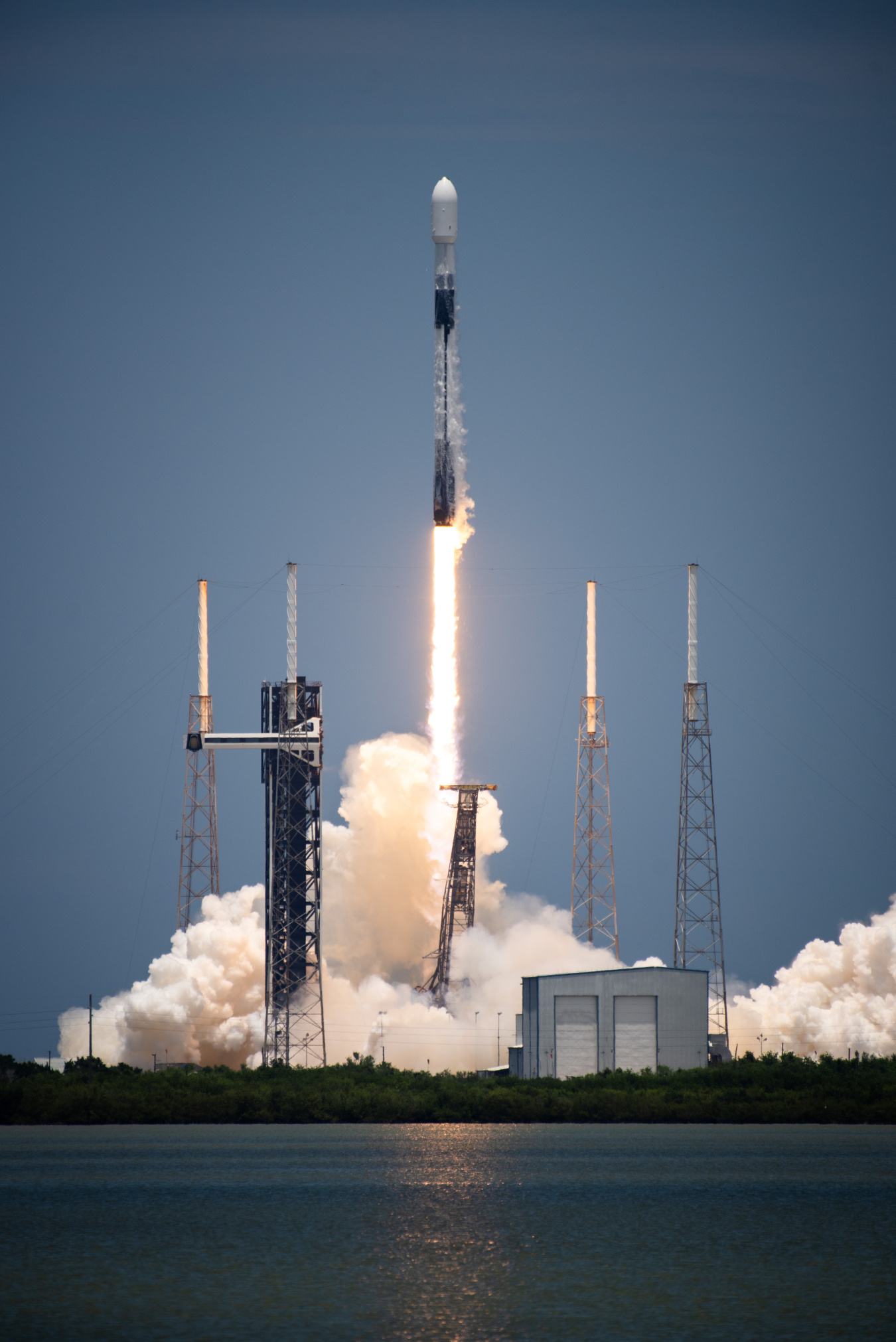 A rocket lifts off from a launchpad leaving behind flames and steam.