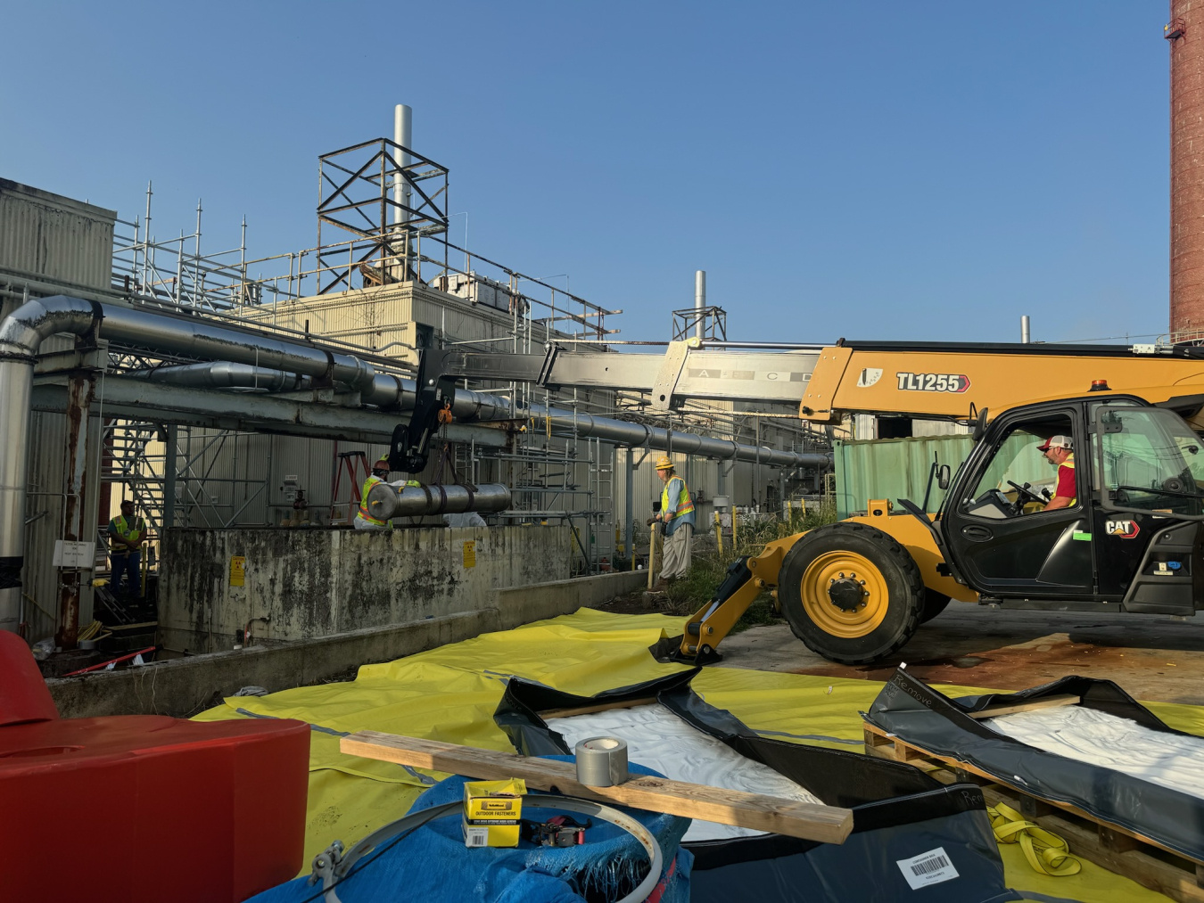 Employees use construction vehicles to remove parts of a building