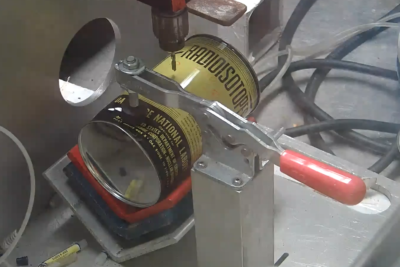 A yellow and black can being vented by a machine