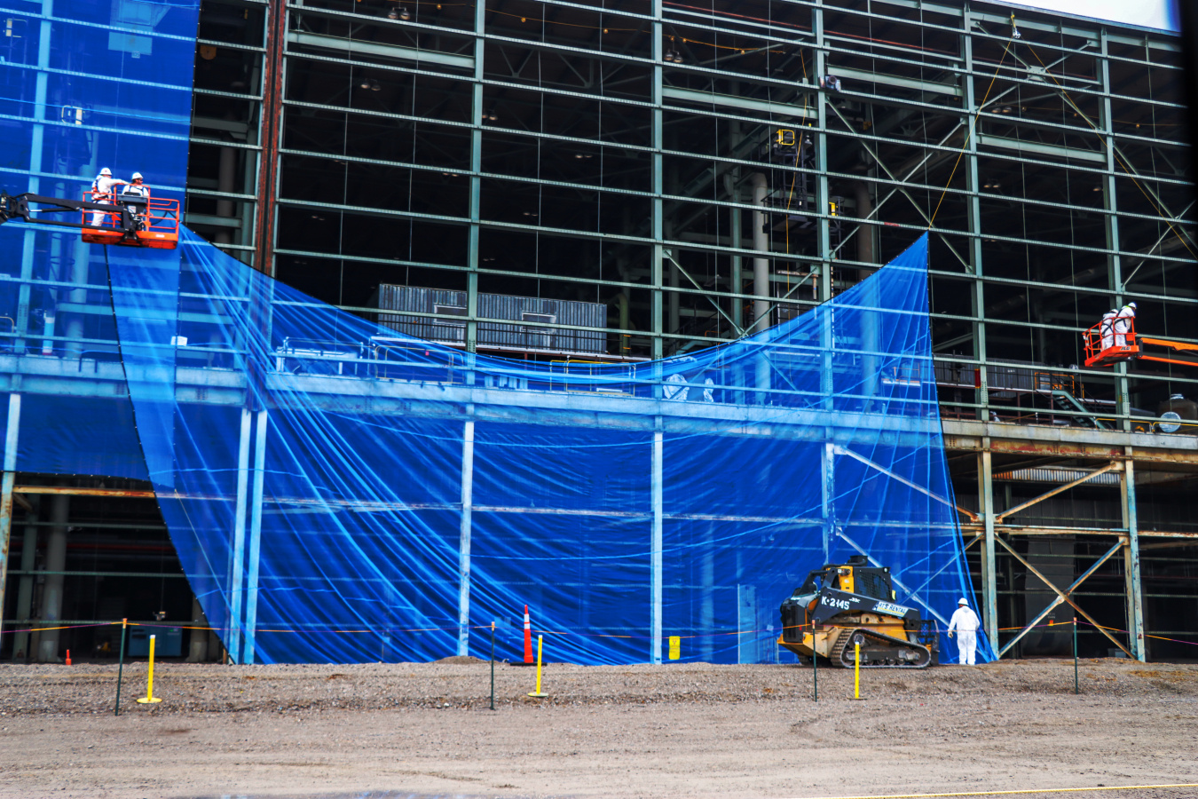 Crews adding blue netting to a building at the Portsmouth Site
