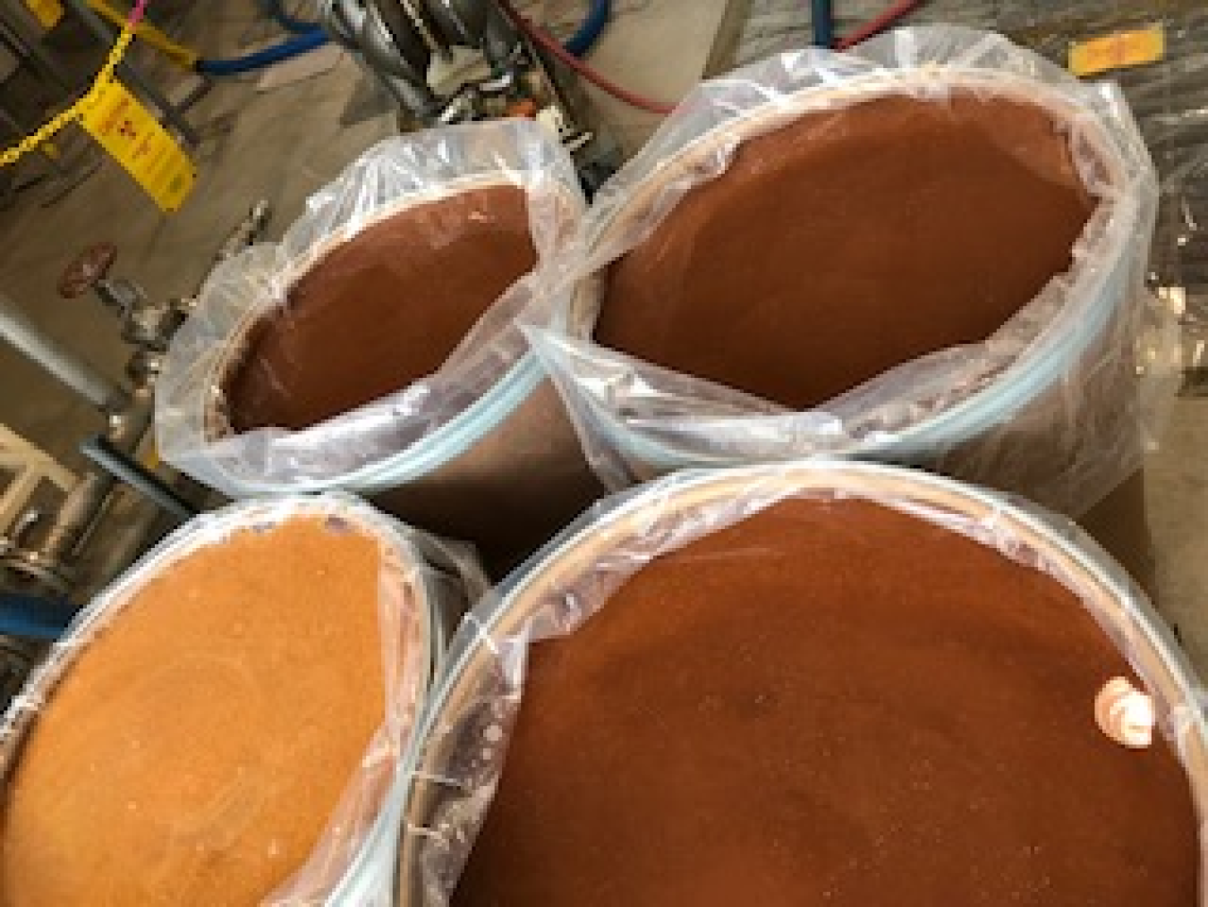 Four large buckets of light and dark brown resin