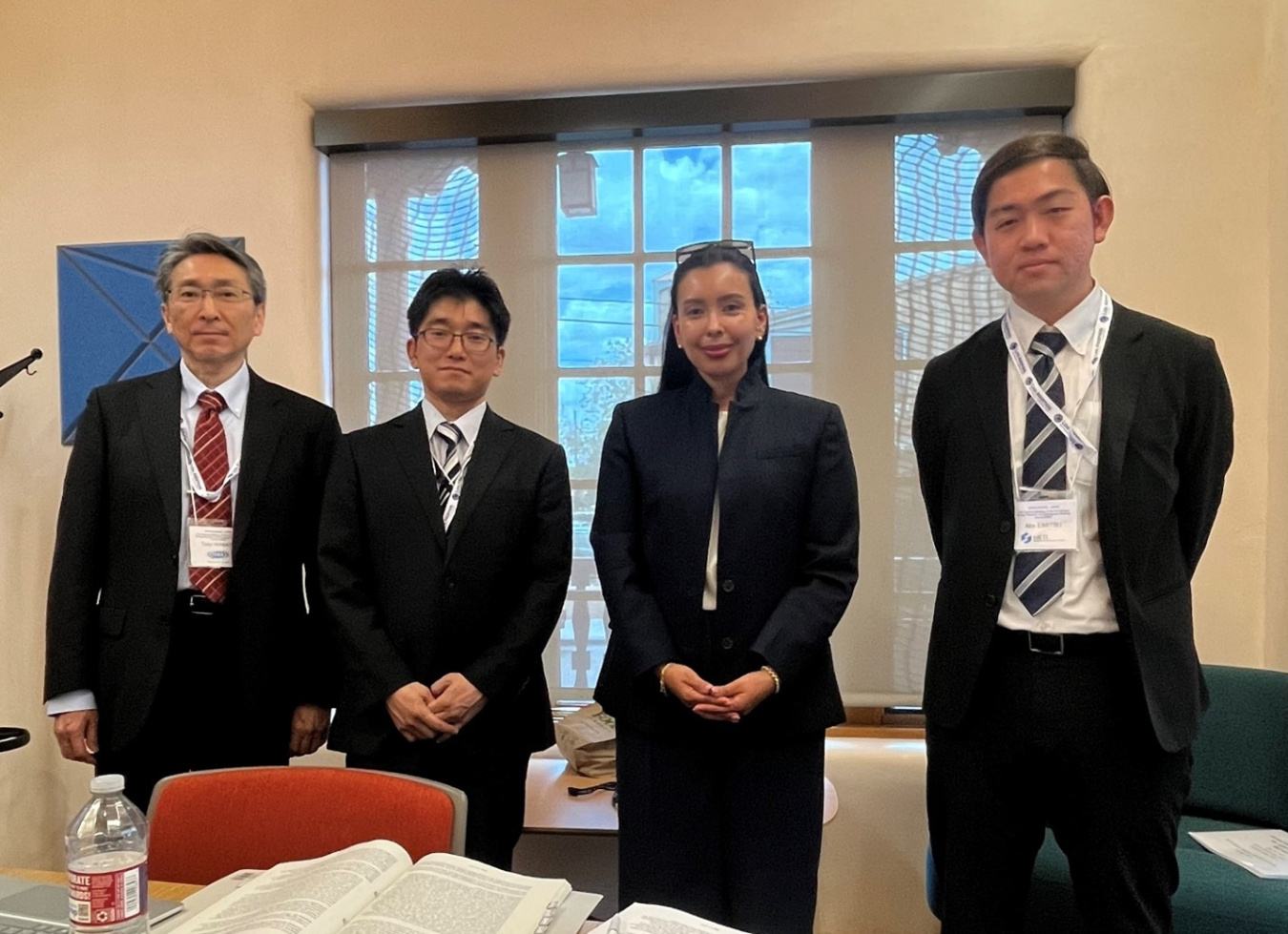 Four professionals pose for a photo in a meeting room 