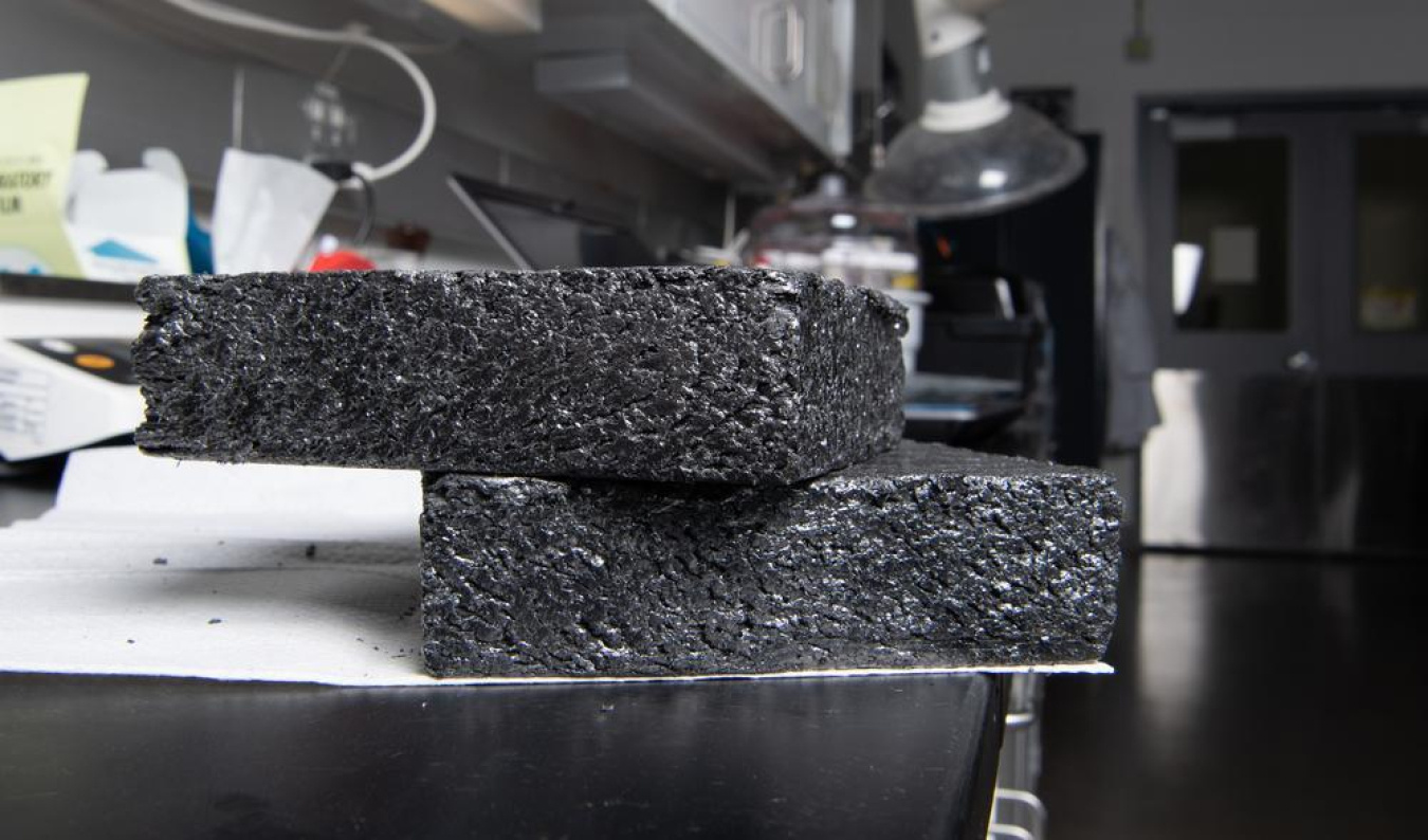 Two blocks of graphite lay on a table in a laboratory setting.