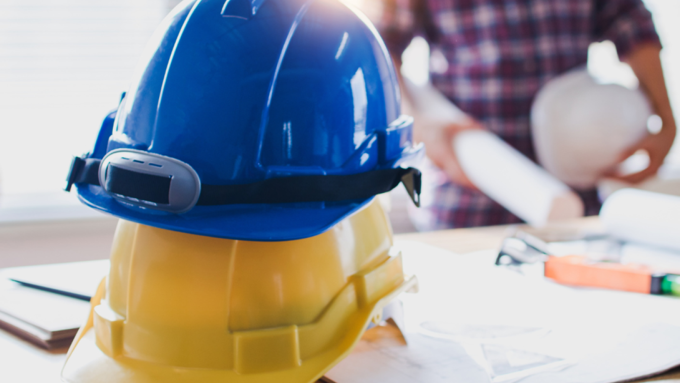 Two construction hats stacked on top of each other on a table.