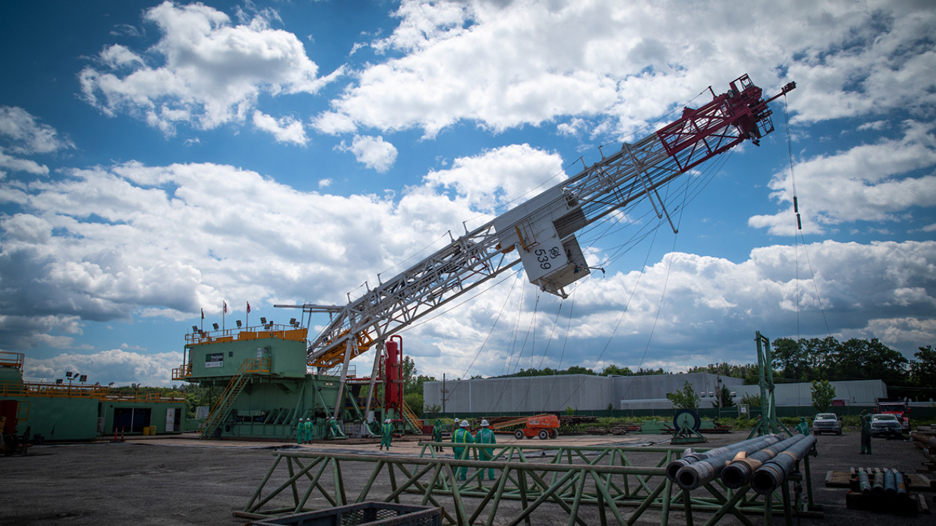 The tower portion of the rig is raised to a 30 degree angle against a blue, cloudy sky.