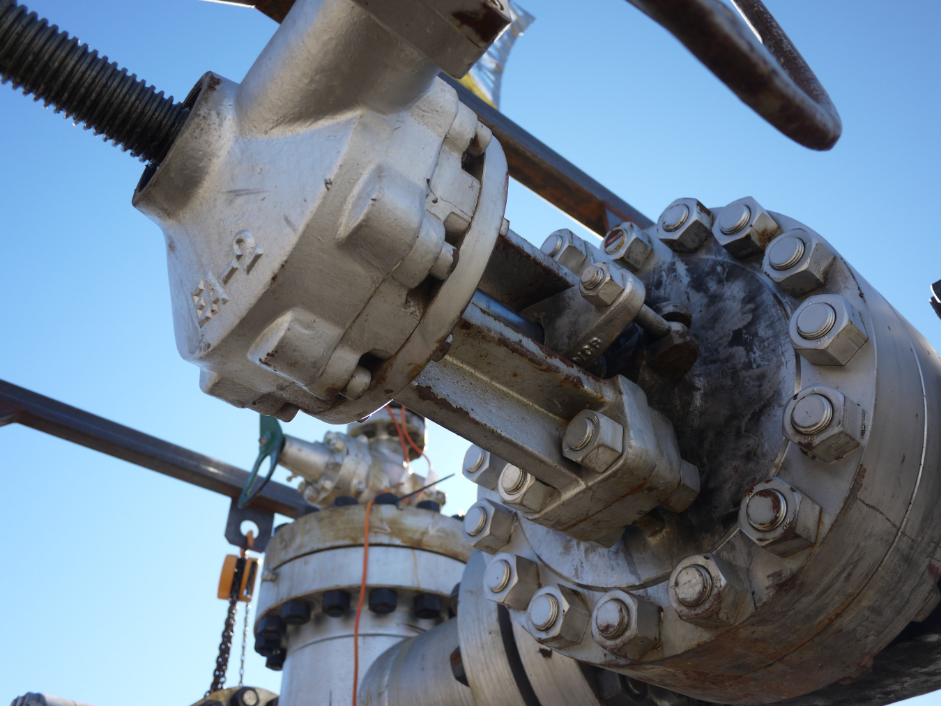 Close-up photo of drill-bit machinery with blue sky in the background.