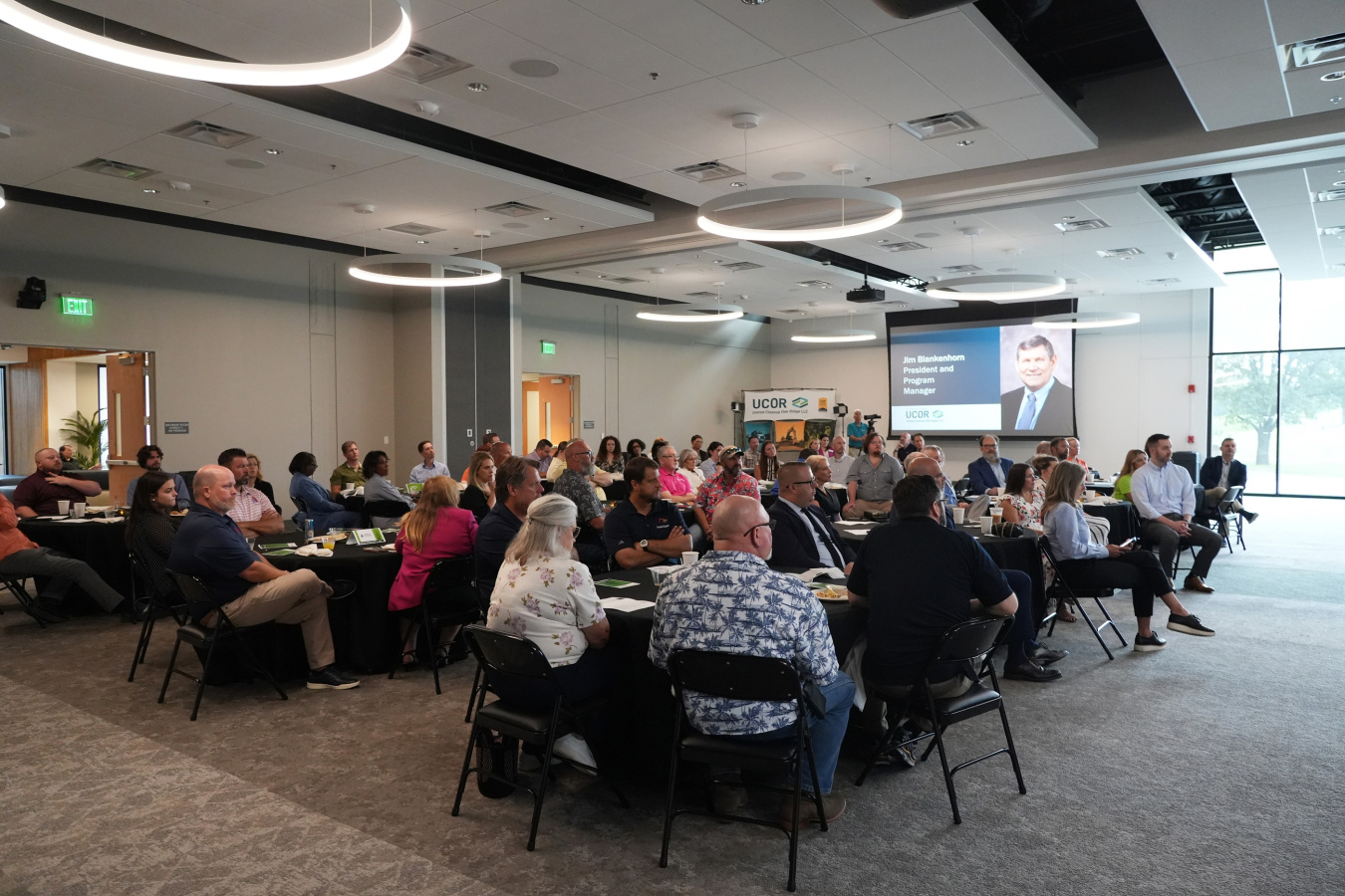 A group of professionals sitting at tables inside a large room for an awards event