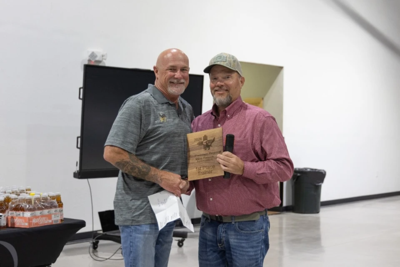 Two professionals shaking hands holding an award