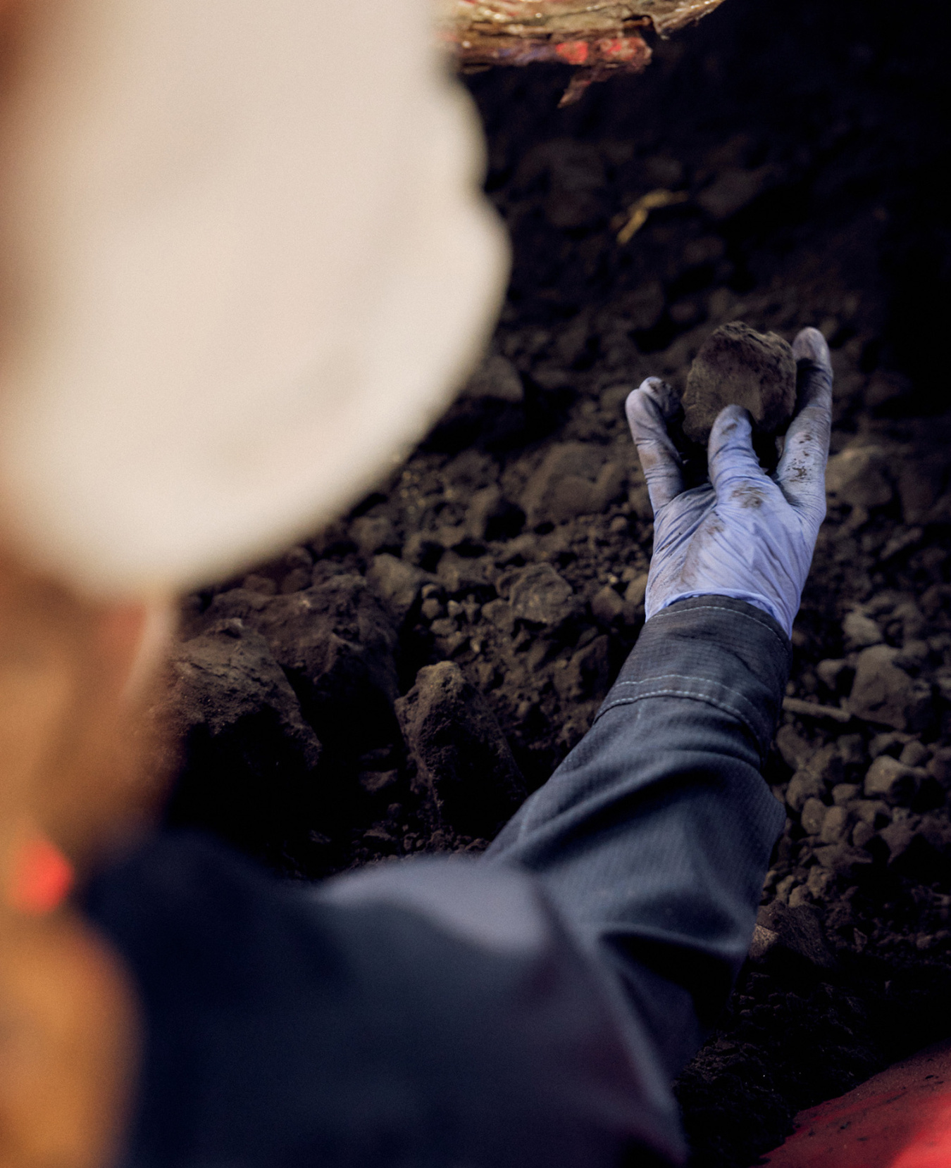 Gloved hand holding ore