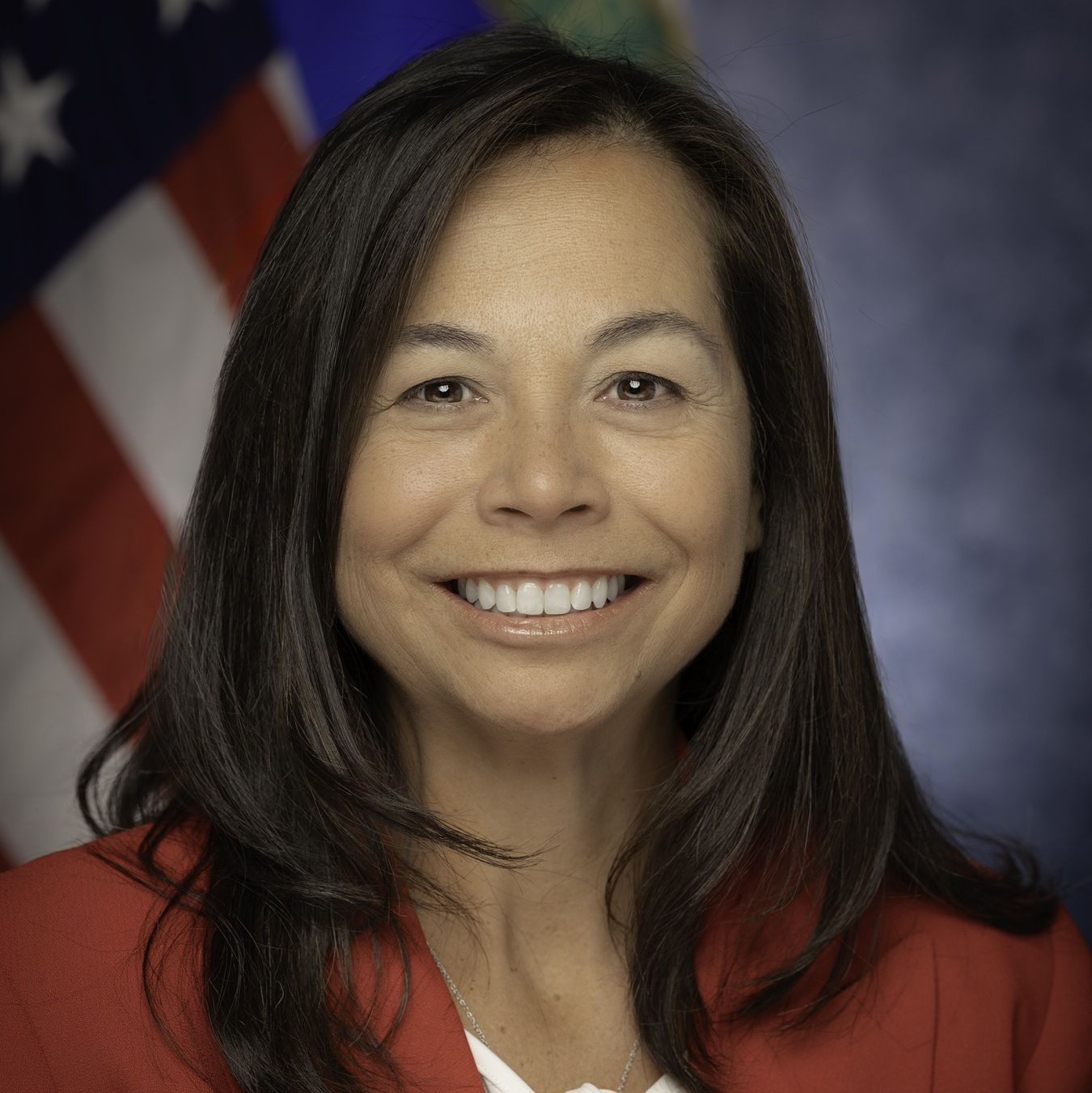 Head and shoulders shot of Catherine Jereza with the American flag in the background.