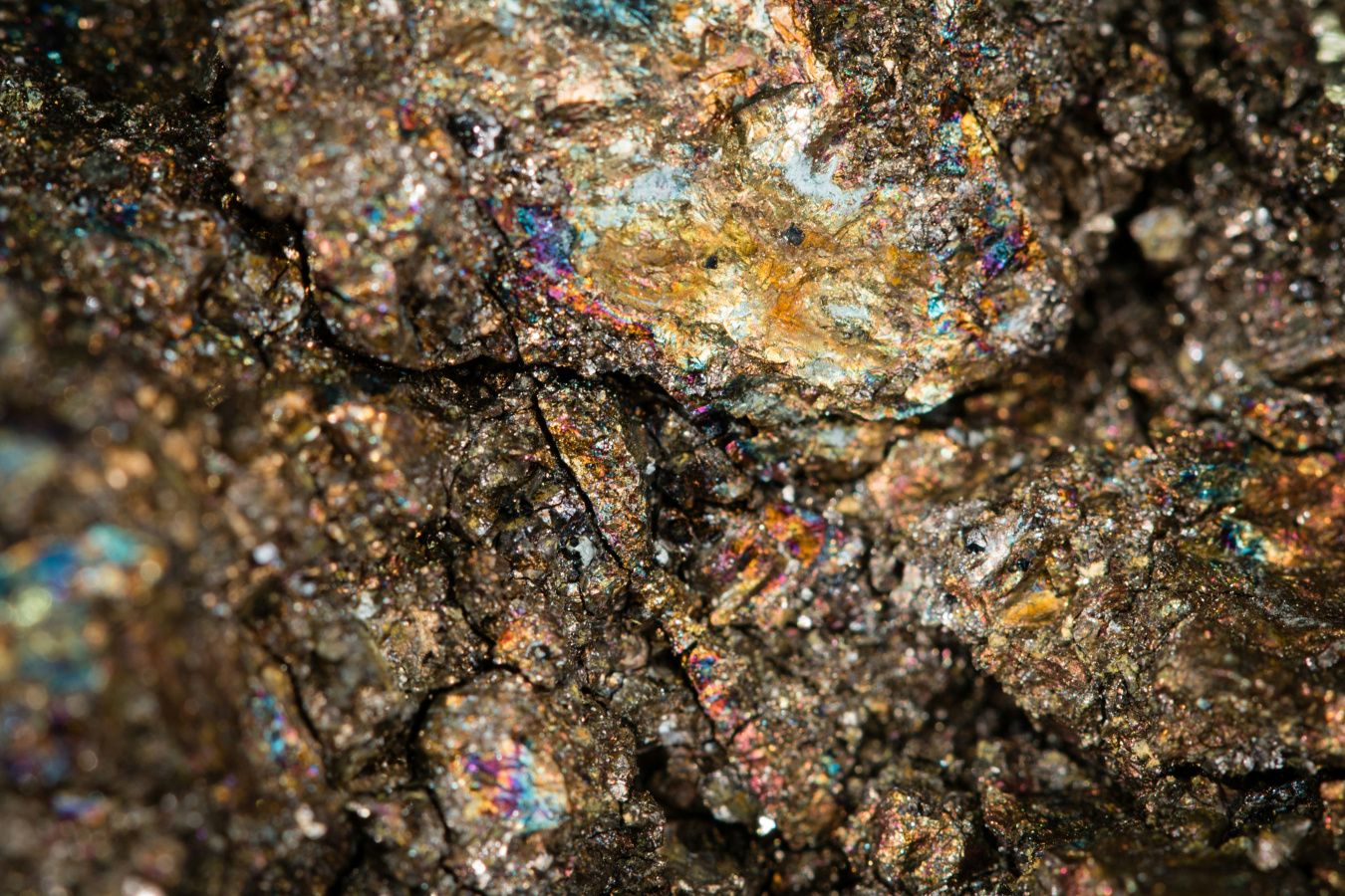 Close-up photo of dark brown stone dotted by bits of why and other bits of vibrant color