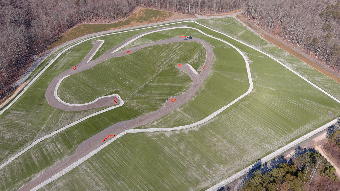 An aerial view of a large green cleared area with roads throughout it 