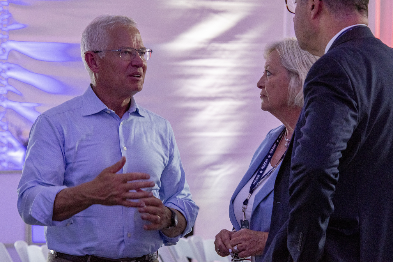 Assistant Secretary of EM speaks with two other professionals at an event
