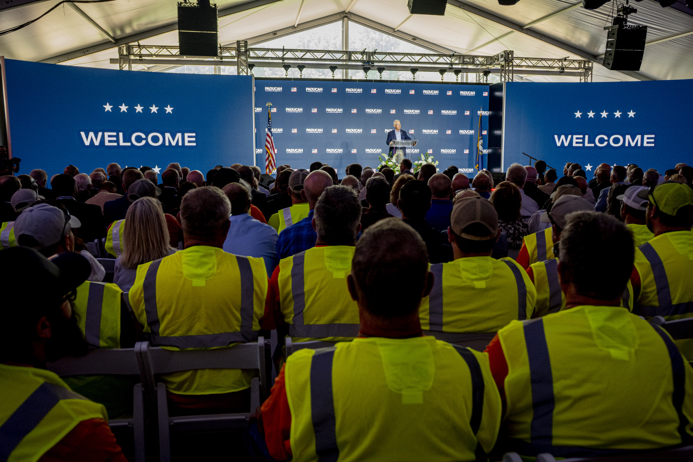 A crowd of employees and professionals looking at the Secretary of Energy give a speech on a stage at the Paducah Site