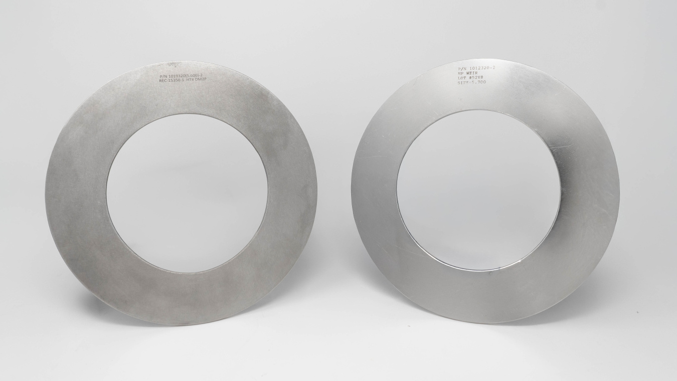 Two circular metal rings on a light grey background
