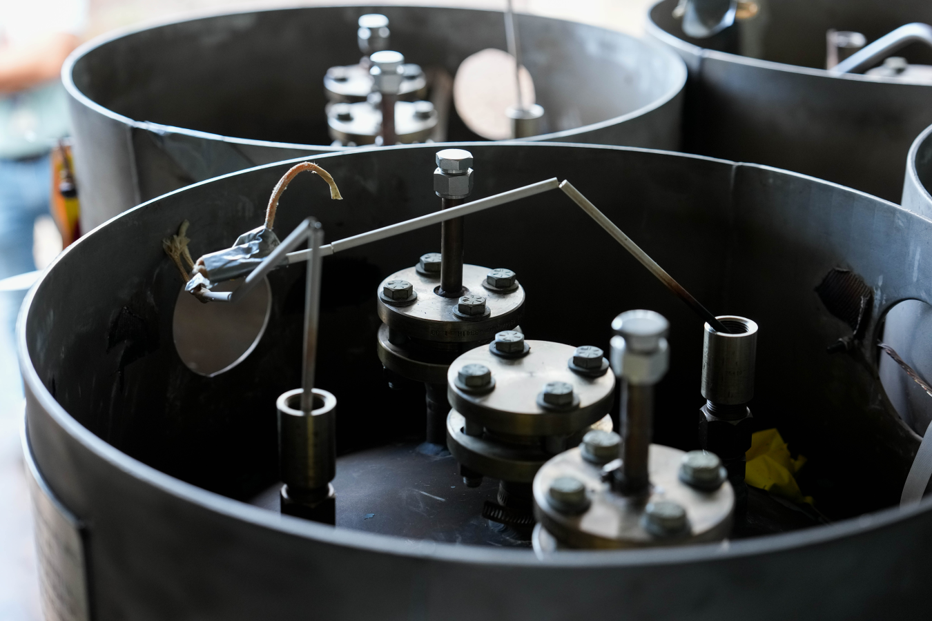 Close-up of FLiBe canisters delivered to Natura Resources, black metallic drums with valves on top.