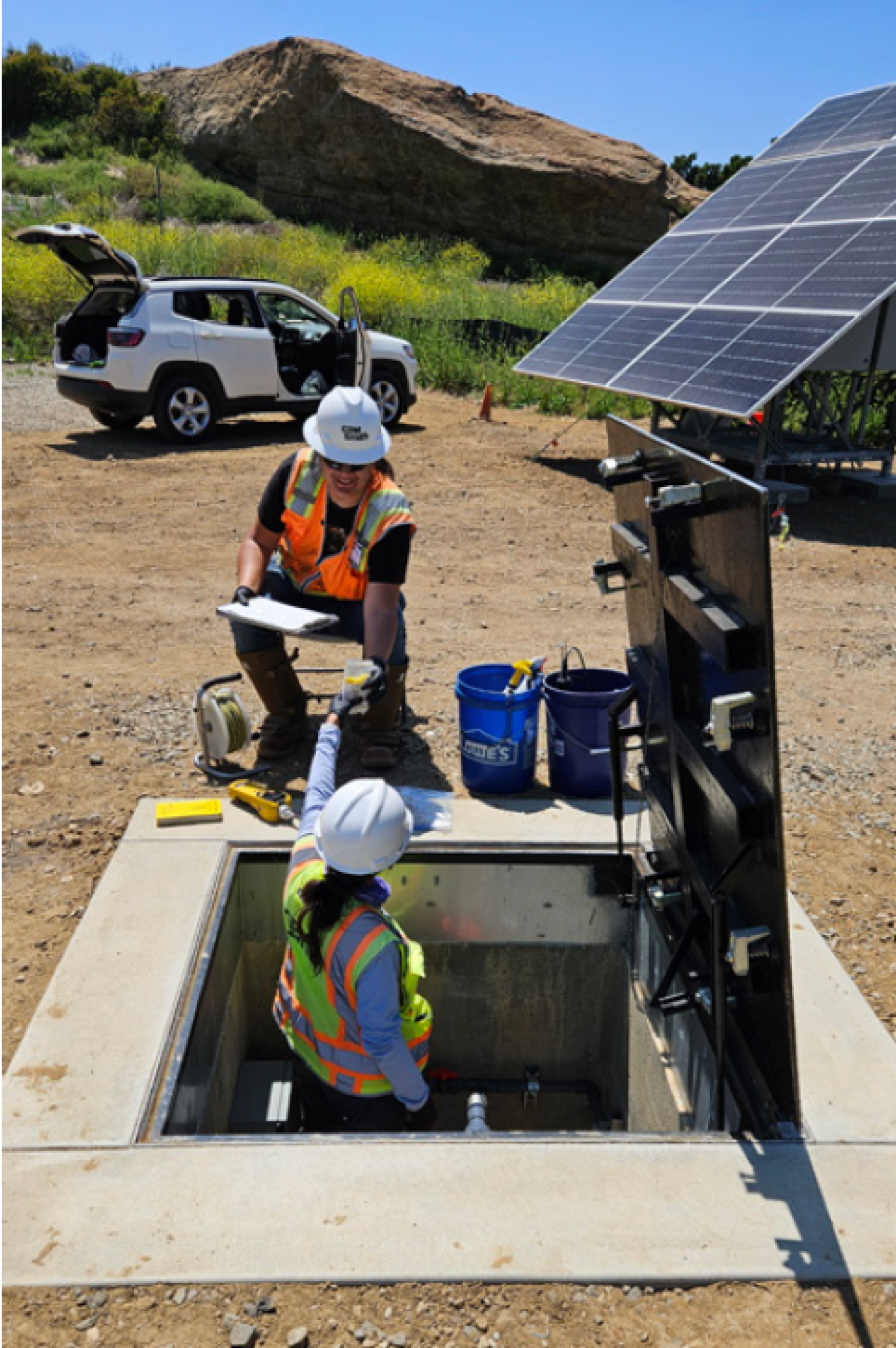 Workers take groundwater samples from a well