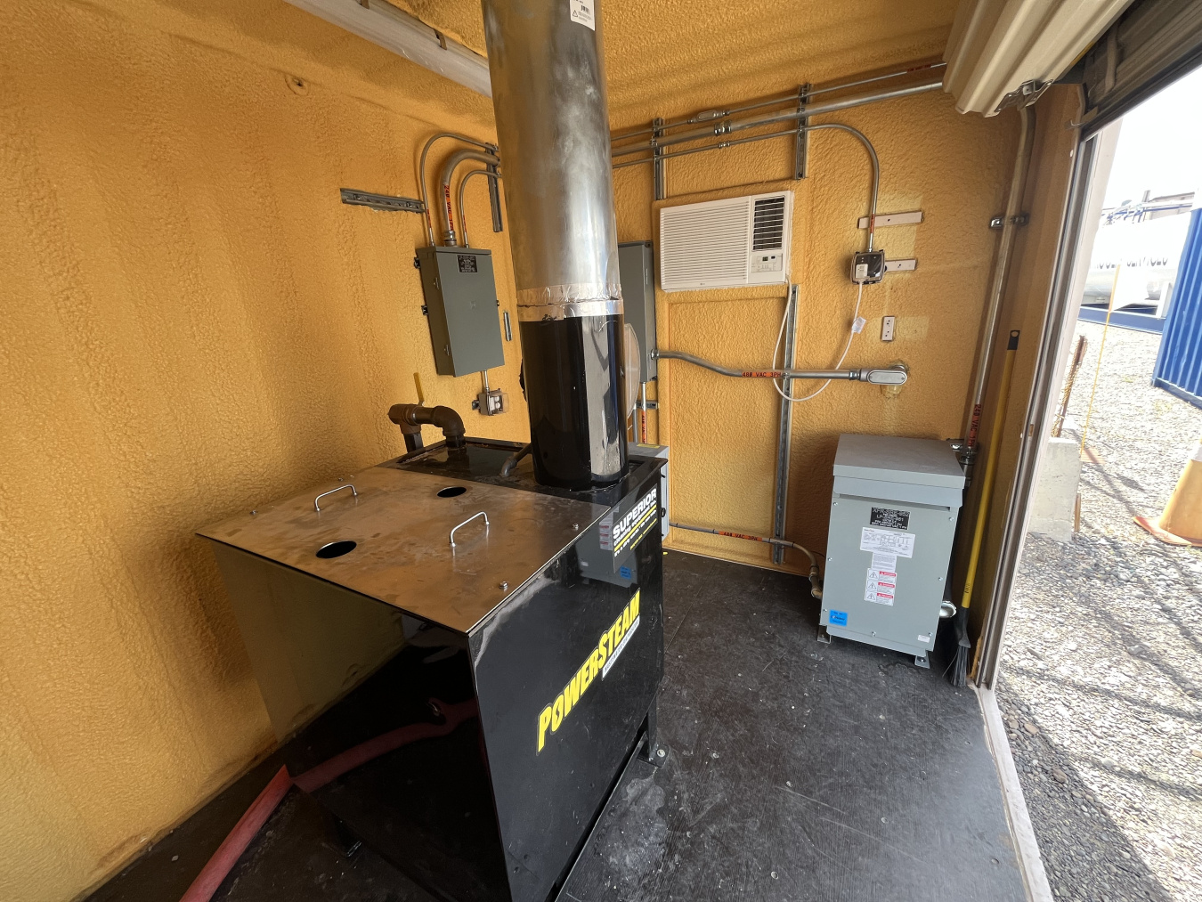 A large black condensate evaporator with a metal chimney coming out the top
