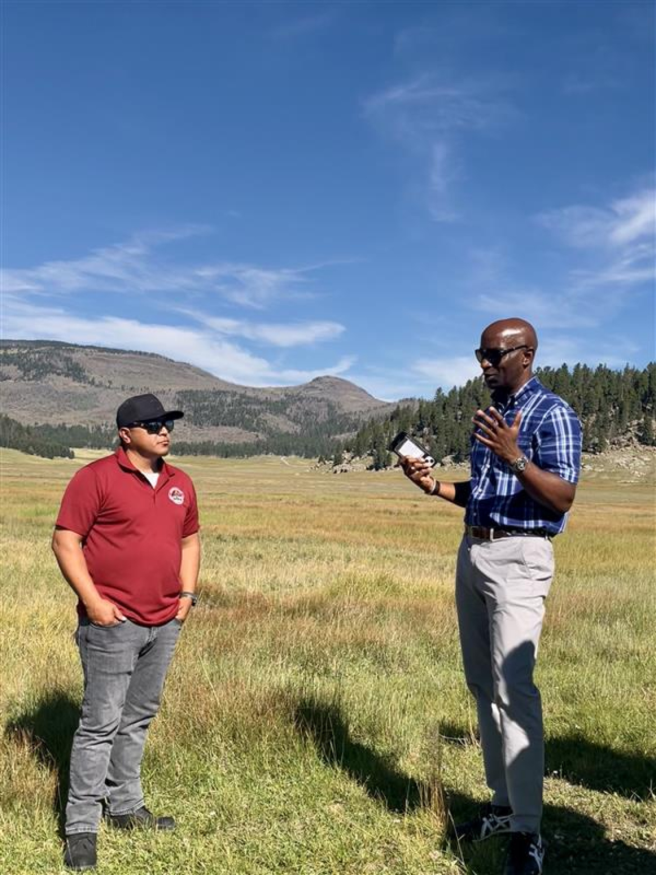 Two professionals standing outside at the Los Alamos Site talking to each other