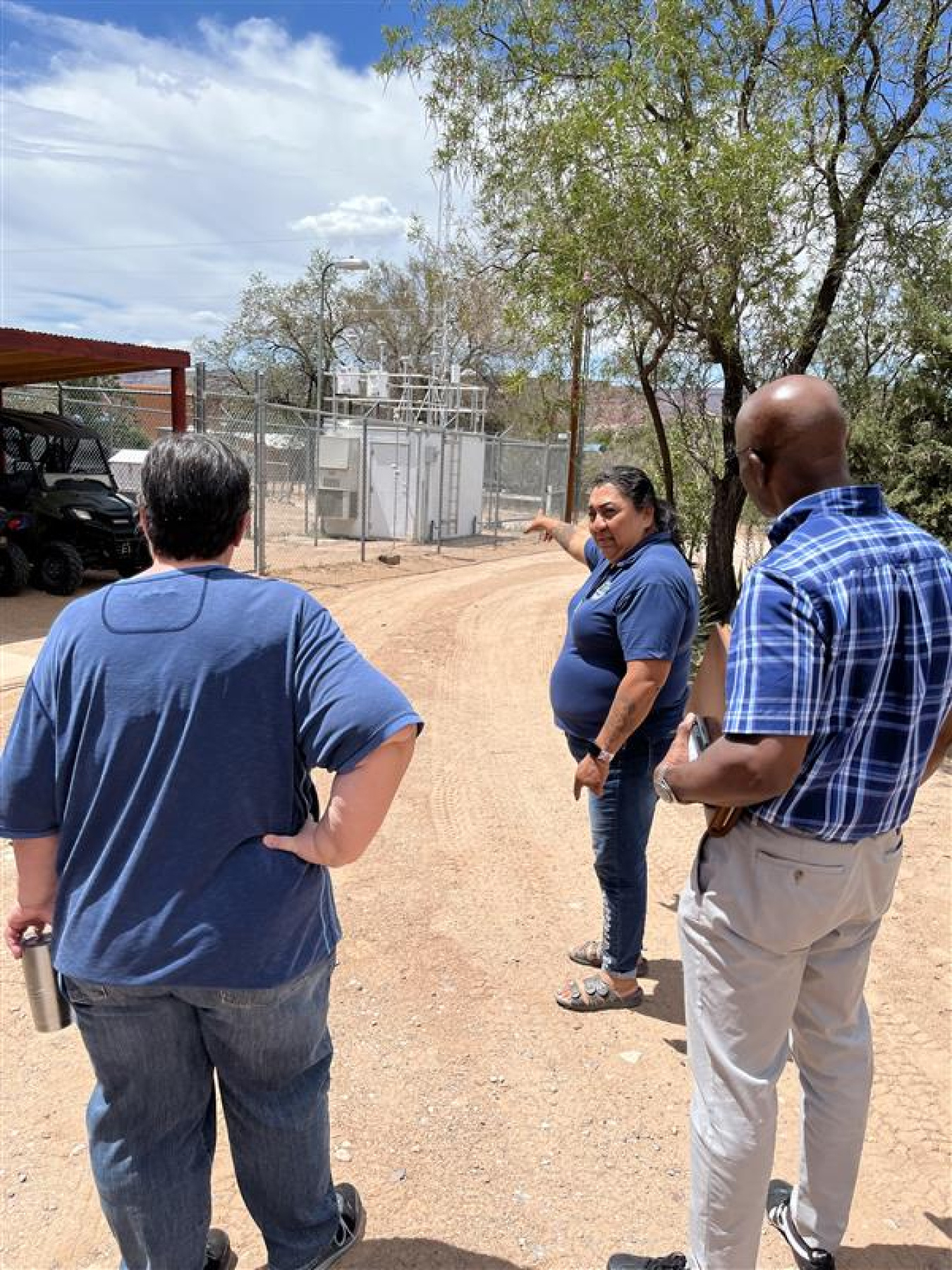 Three professionals taking a tour outside at the Los Alamos site