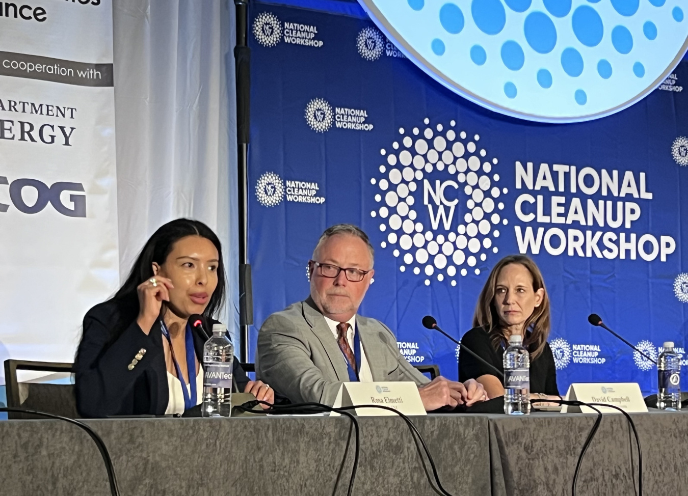 Panelists sitting on stage at a conference participating in a discussion