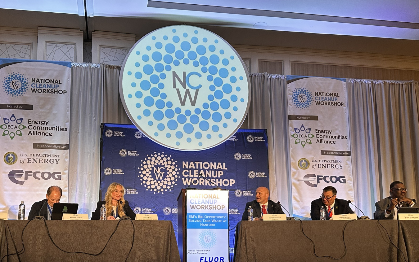 Panelists sitting on stage at a conference participating in a discussion