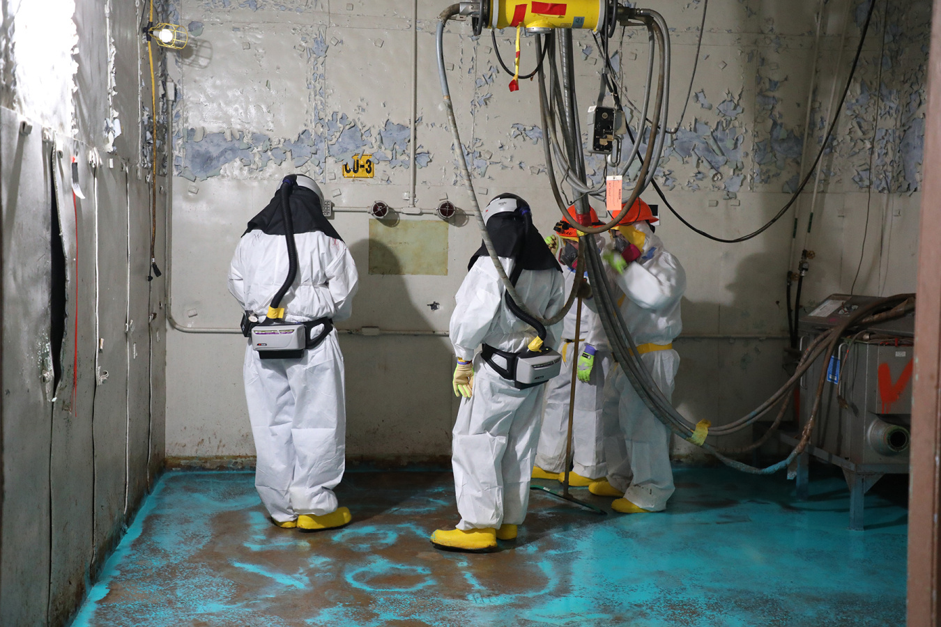 Employees in hazmat suits work