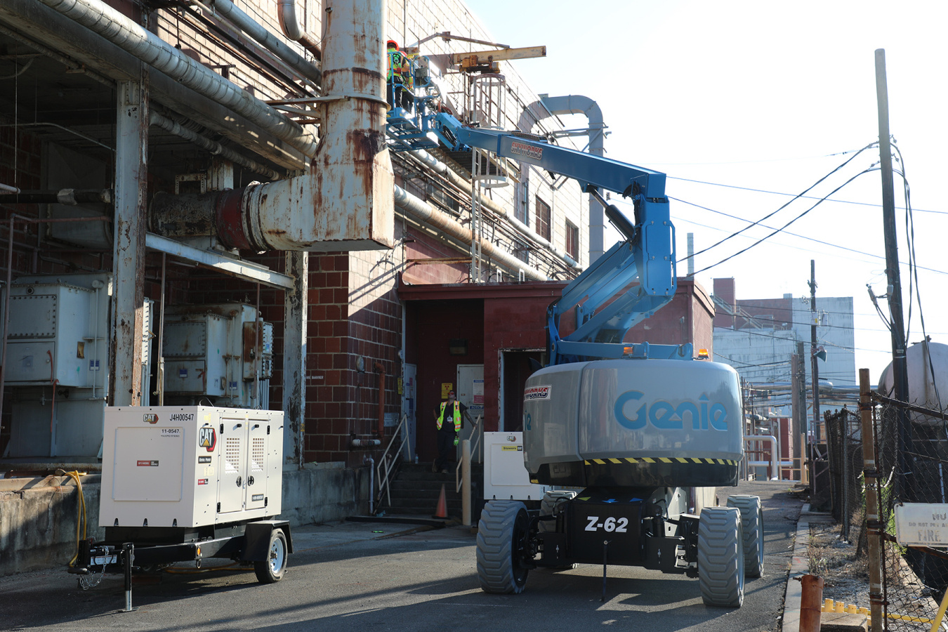 A blue construction crane conducting work on the side of a building