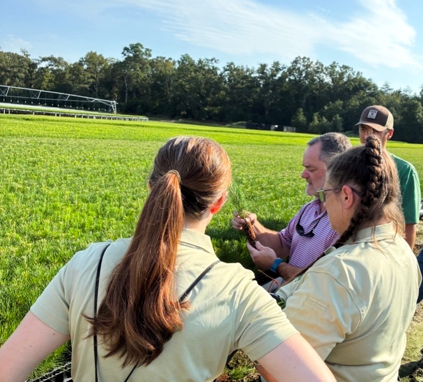 Four employees outside at the Savannah River Site looking at a screen that one of them is holding