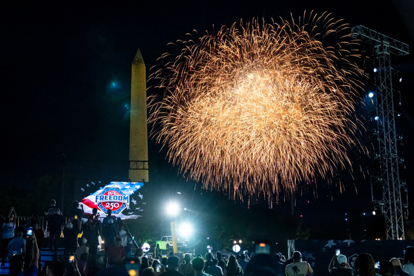 Fireworks explode with the Washington Monument in the background. A UFC Freedom 250 logo is visible on a large TV screen.