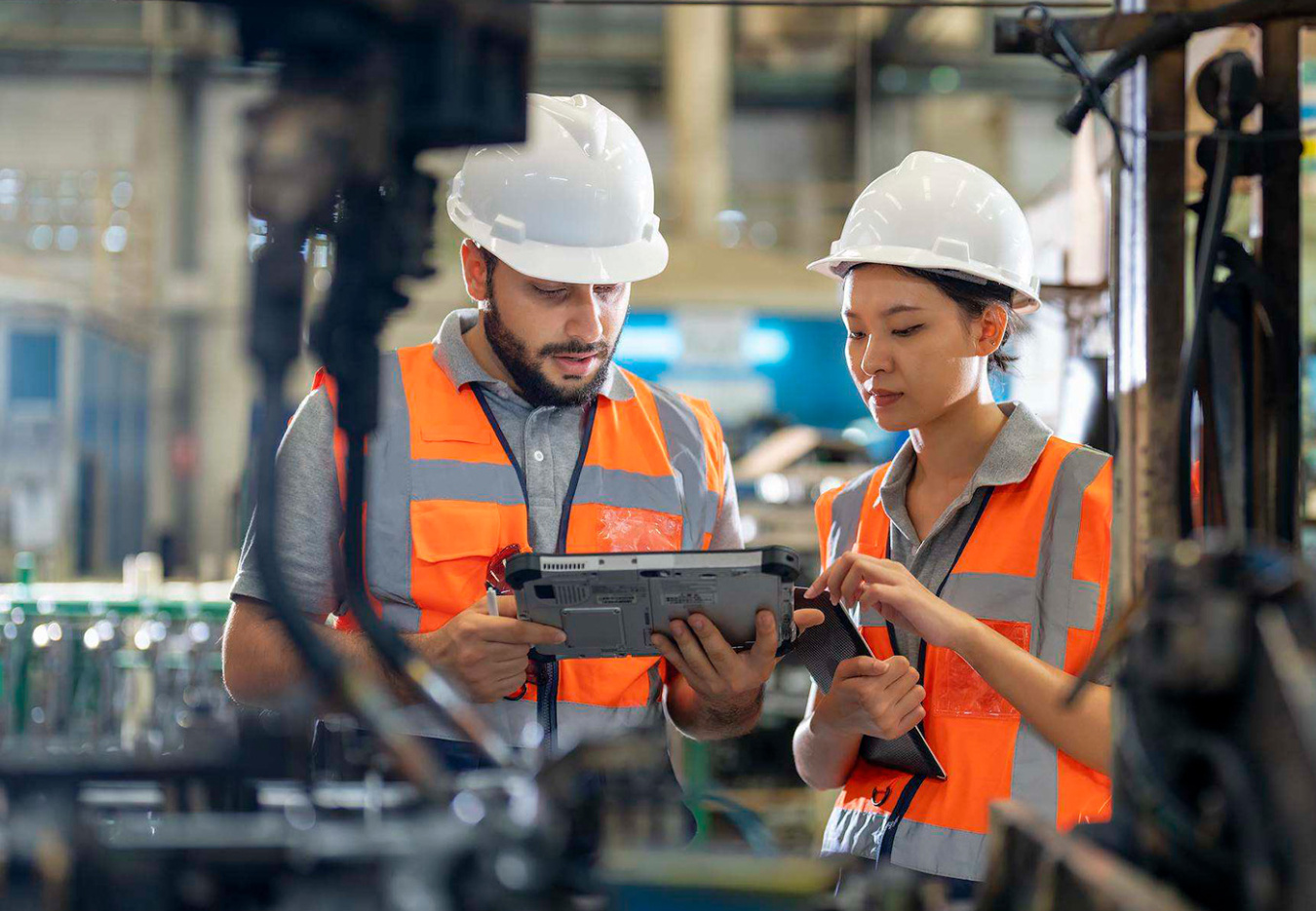 Technicians review tablet data in industrial facility