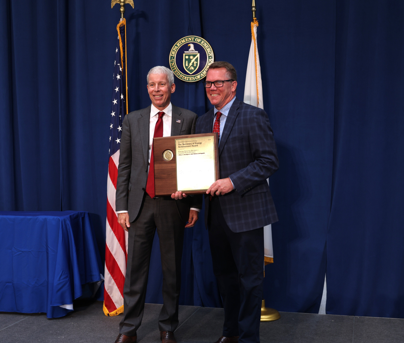 Two professionals holding an award posing for a photo together