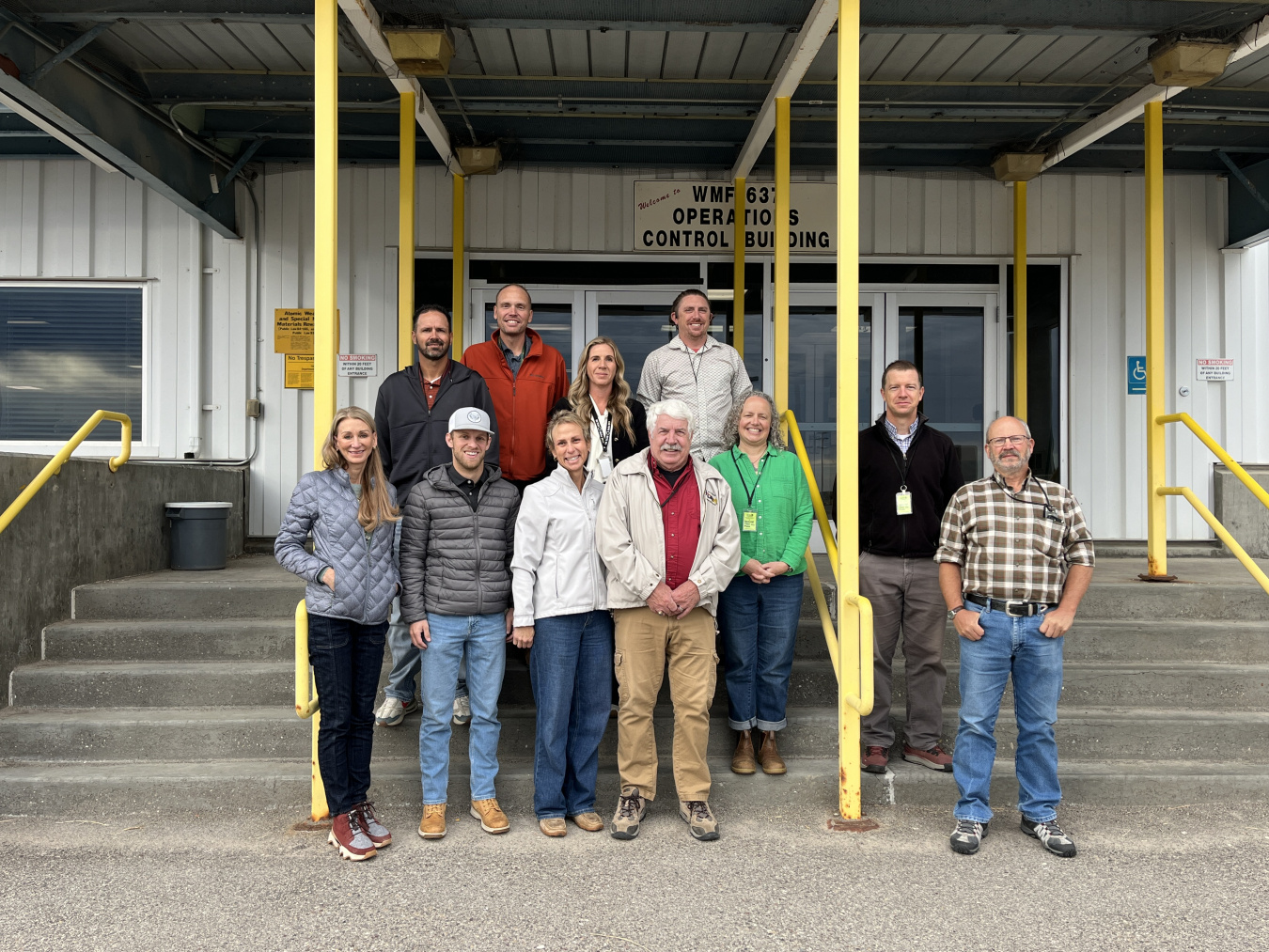 A group of individuals pose for a photo outside a building 