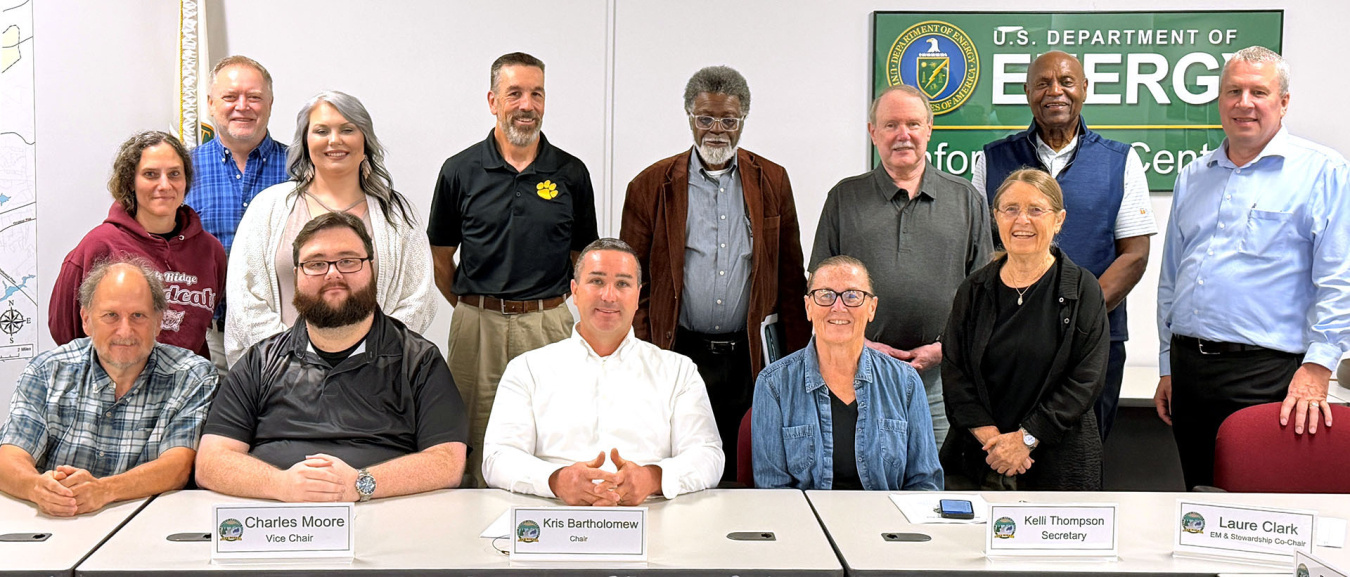 A group photo of the Oak Ridge Site Specific Advisory Board's FY 2026 group seated and standing around a meeting table.