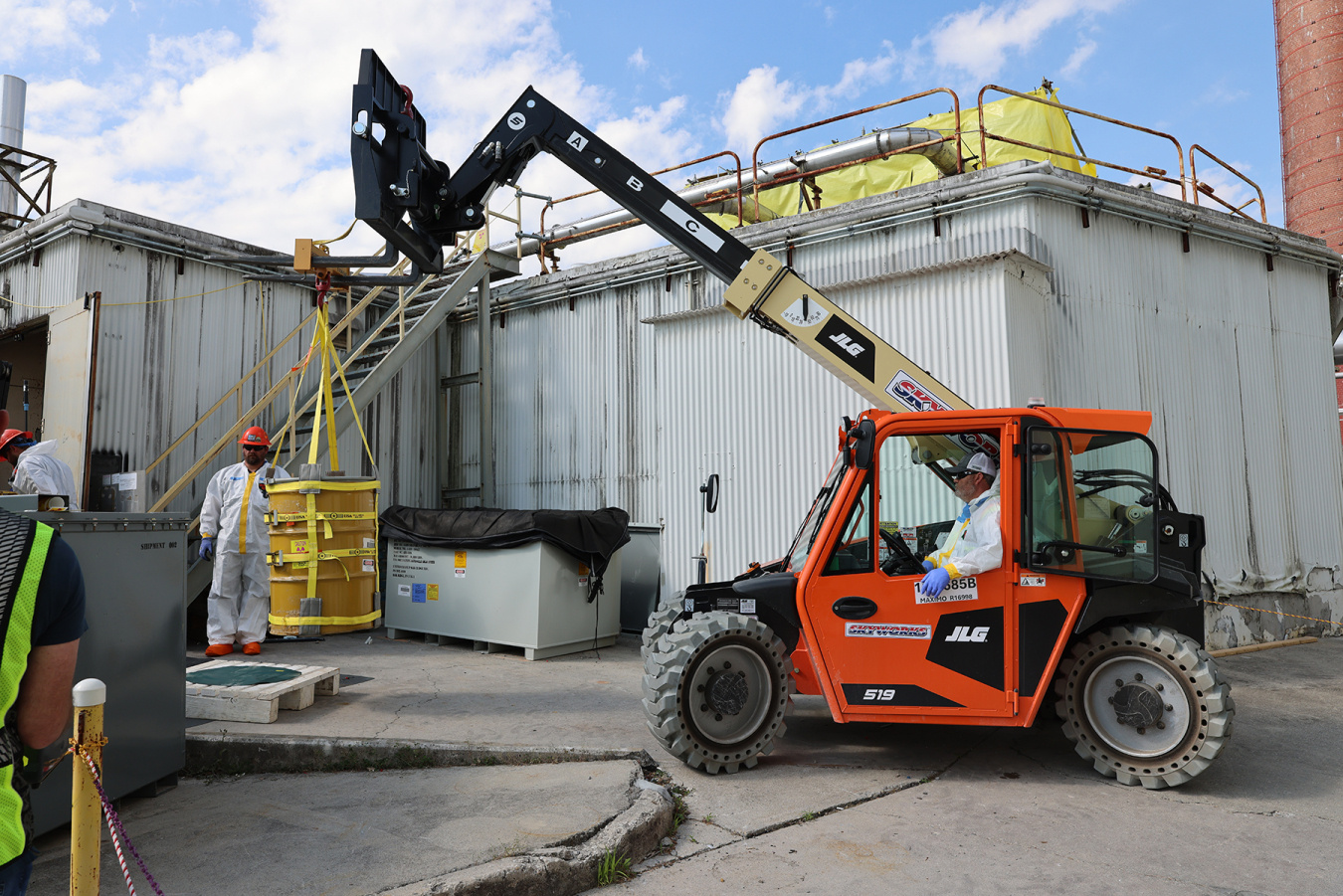 An orange construction vehicle carries out demolition work at the Oak Ridge Site