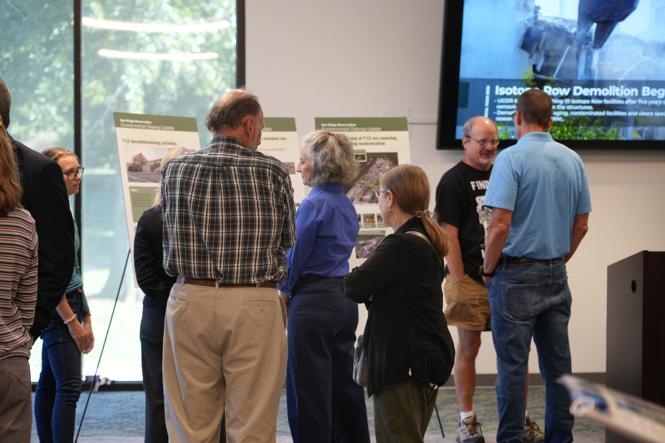 A group of people looking at posters set up around a room 